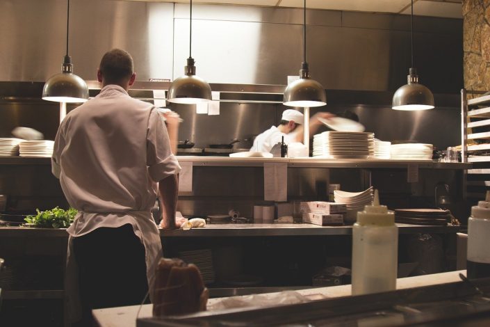 Photo of a chef working in a polished kitchen restaurant space.